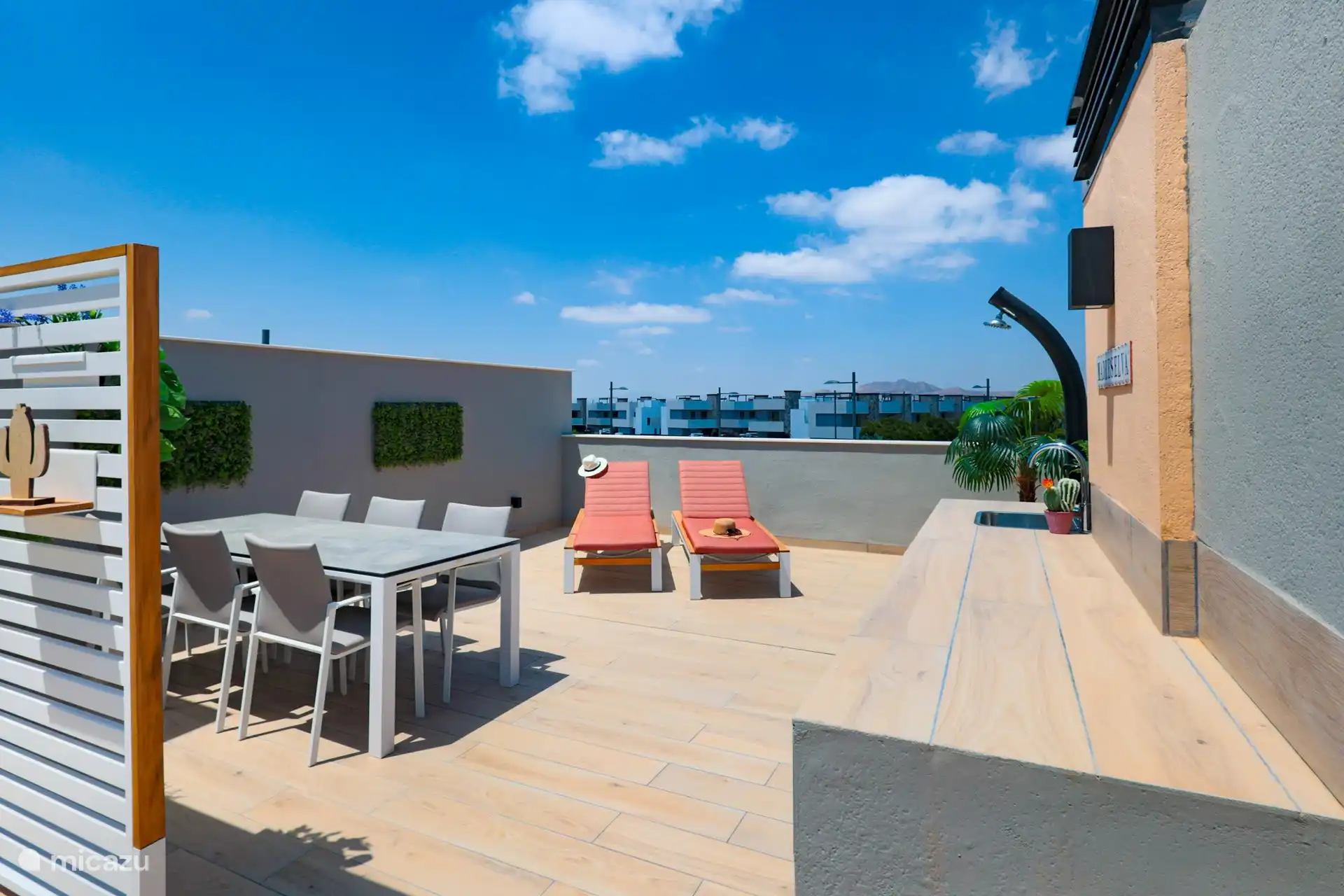 Terrasse sur le toit avec chaises longues et douche extérieure
