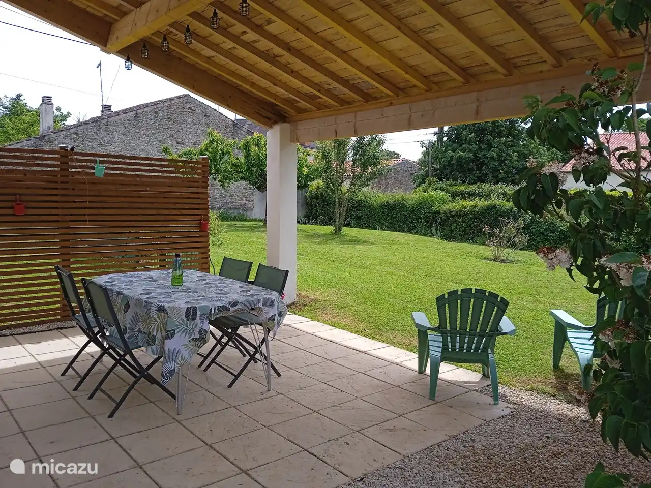 Patio bajo una pérgola en la parte delantera de la propiedad