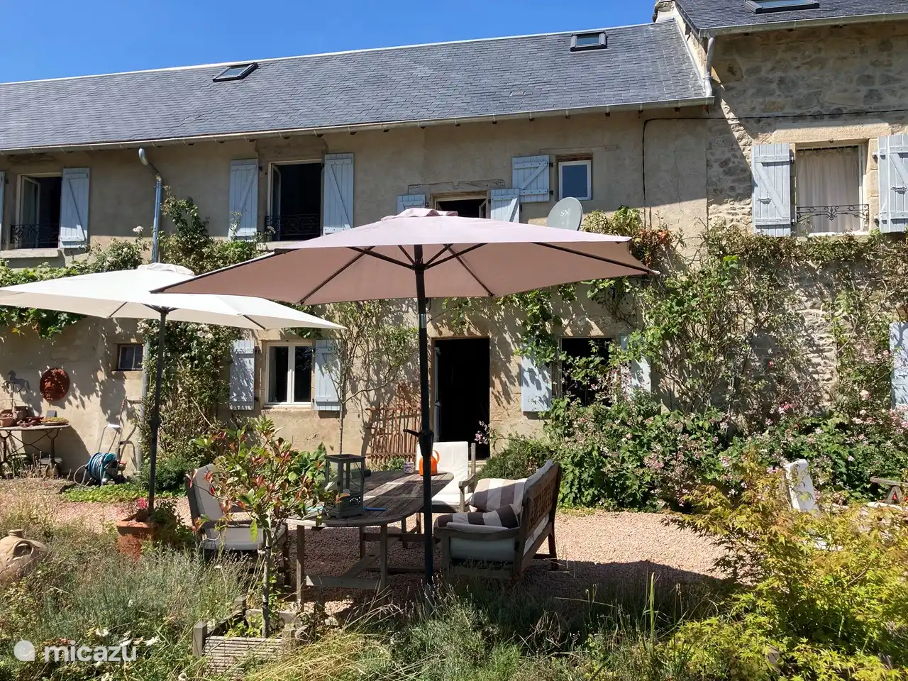 terrasse devant la maison avec parasols, directement accessible depuis la cuisine