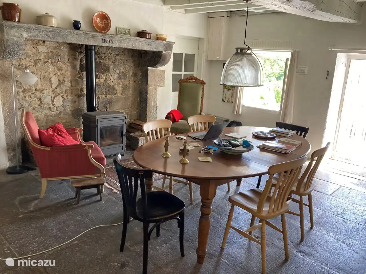 la cuisine avec table à manger et poêle à bois sous la belle cheminée