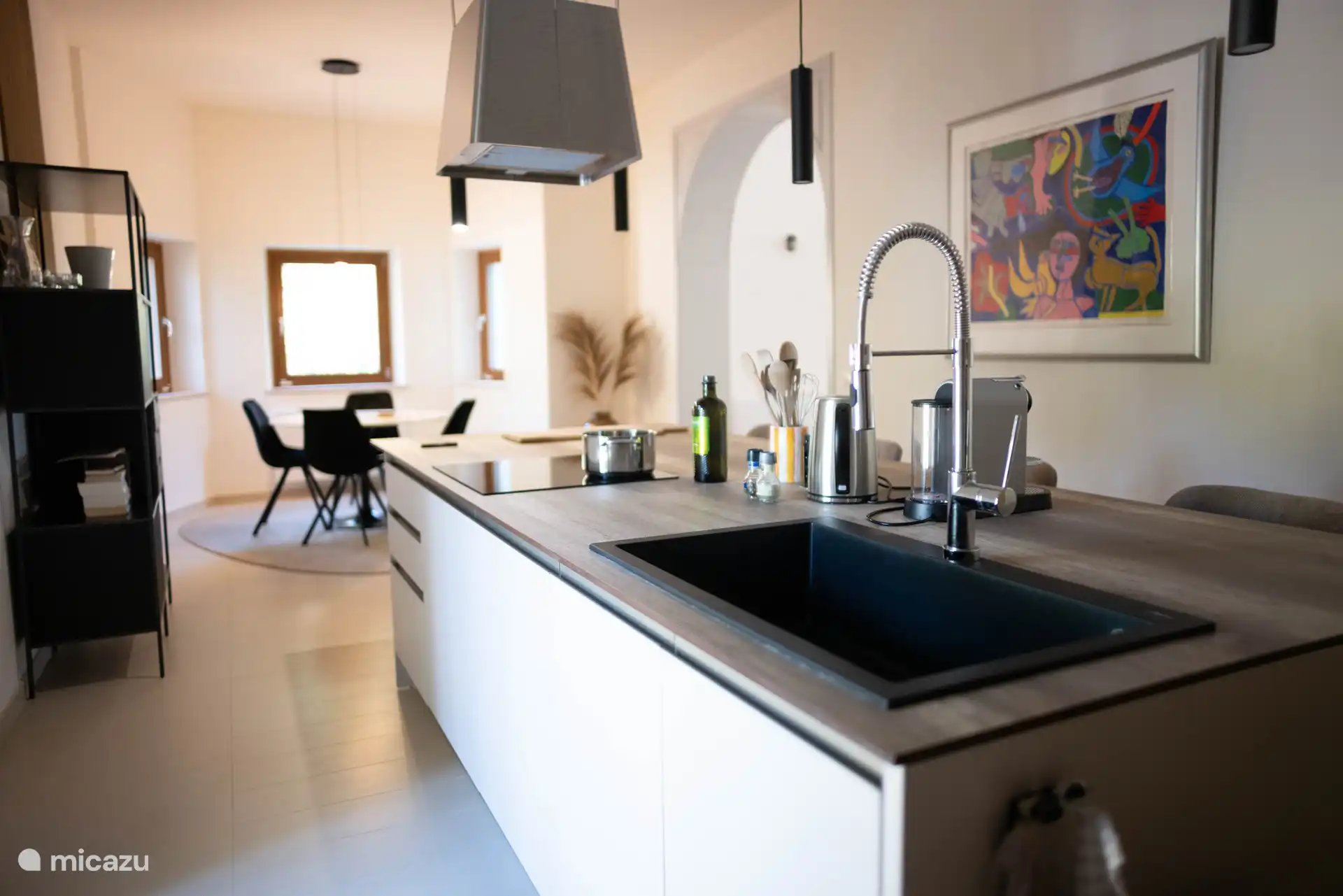 La cuisine avec îlot de cuisson, bar et sièges