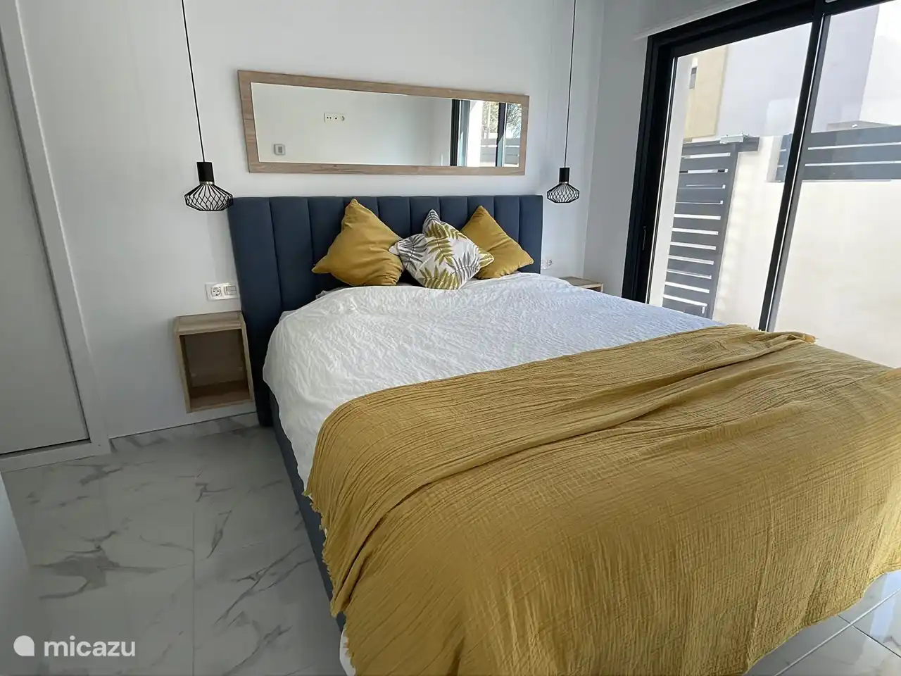 Schlafzimmer im Erdgeschoss mit bequemem Kingsize-Bett, Einbauschränken und eigenem Badezimmer.