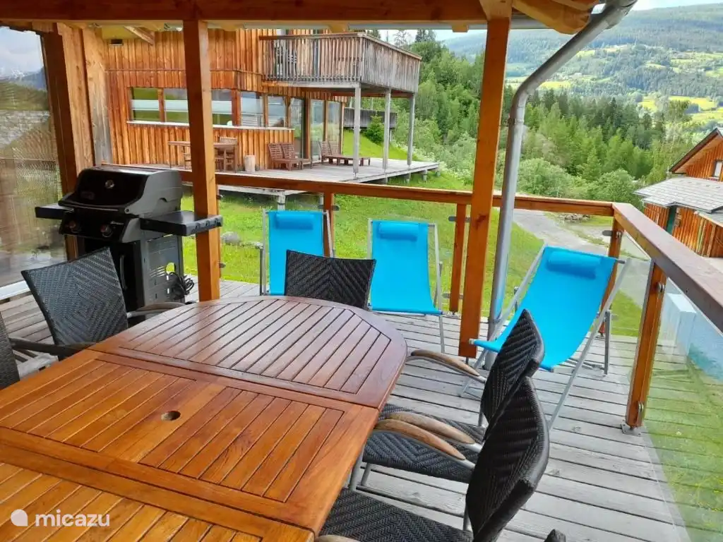 Porche con parrilla Weber, comedor y zona de relax.