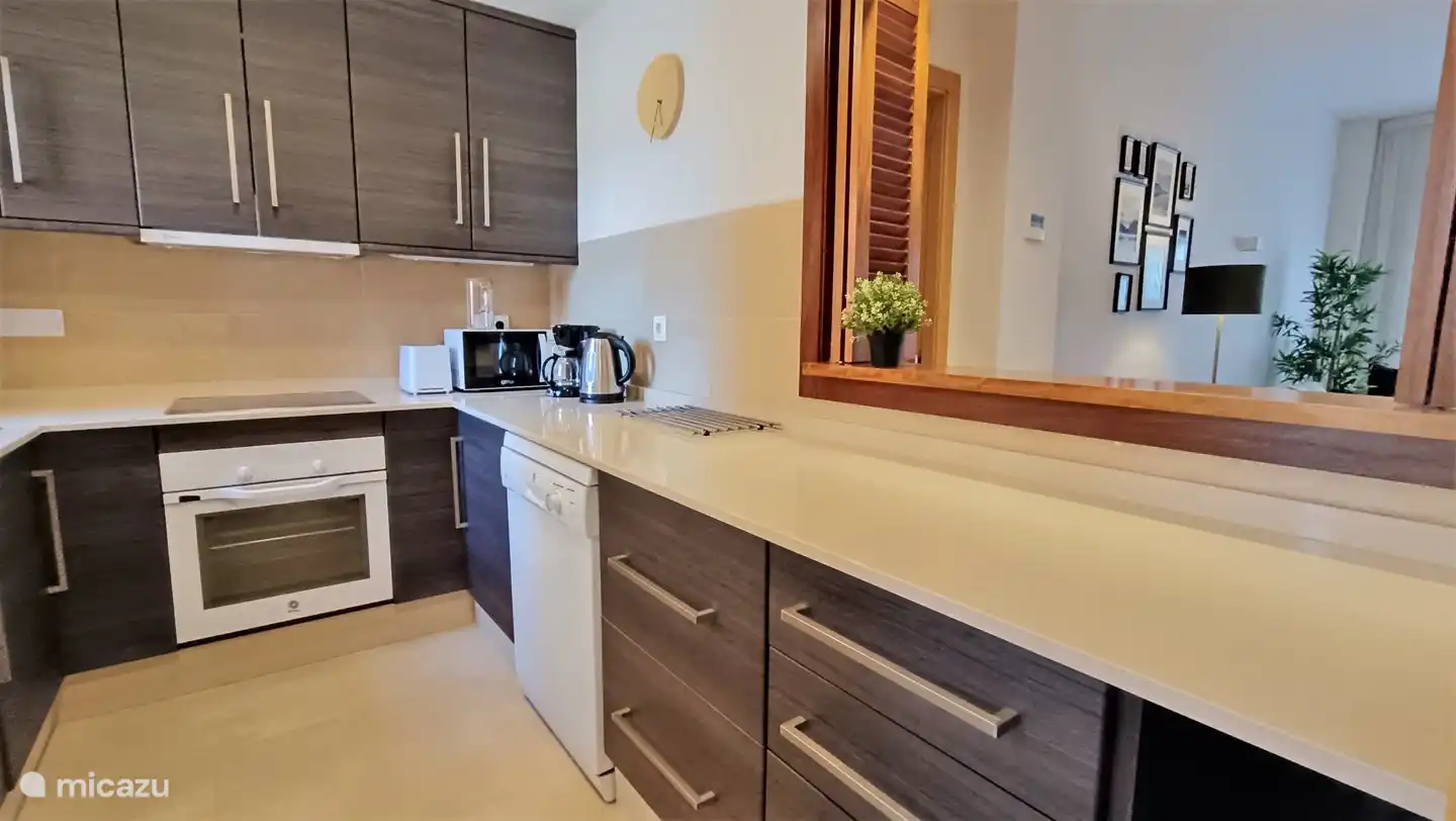 Cocina completa con electrodom&#233;sticos y lavadora.