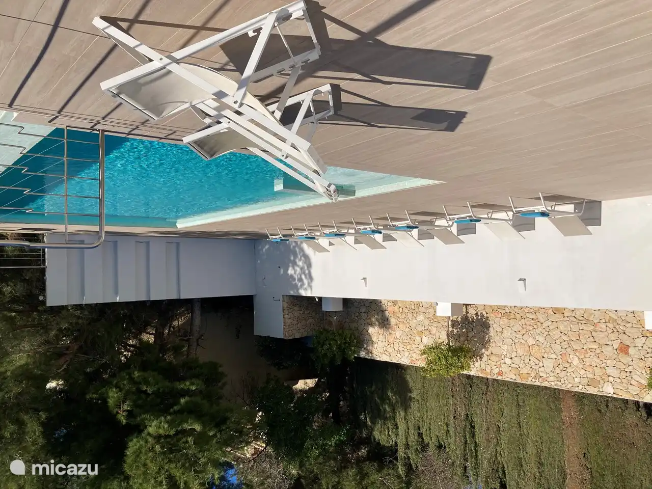 eine große Terrasse mit Sonnenliegen