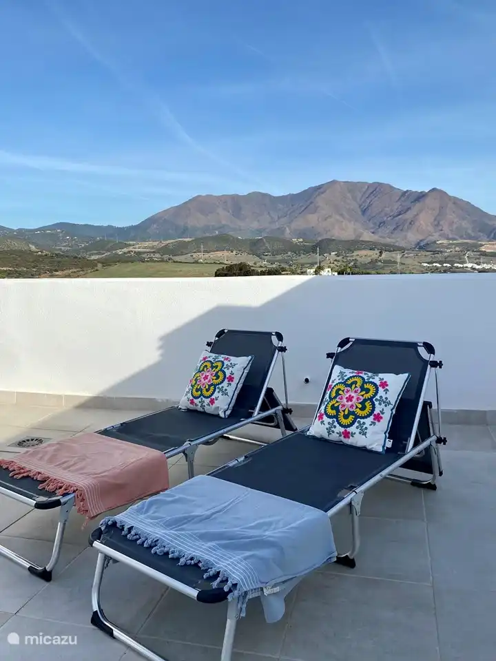 Eine große Dachterrasse mit Loungebereich, Sonnenliegen und Außendusche. Von der Dachterrasse hat man einen wunderschönen Blick über die Bucht von Estepona, die Berggipfel und man kann Gibraltar und Marokko sehen.