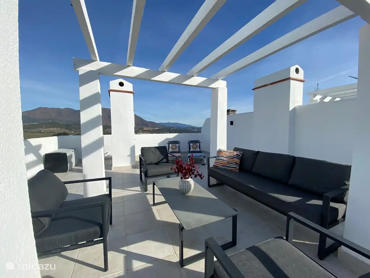 Eine große Dachterrasse mit Loungebereich, Sonnenliegen und Außendusche. Von der Dachterrasse hat man einen wunderschönen Blick über die Bucht von Estepona, die Berggipfel und man kann Gibraltar und Marokko sehen.
