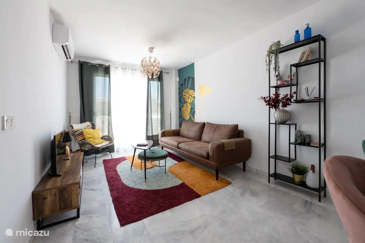 Ein gemütlich eingerichtetes Wohnzimmer mit Schiebetüren zur Terrasse mit Klimaanlage/Heizung.