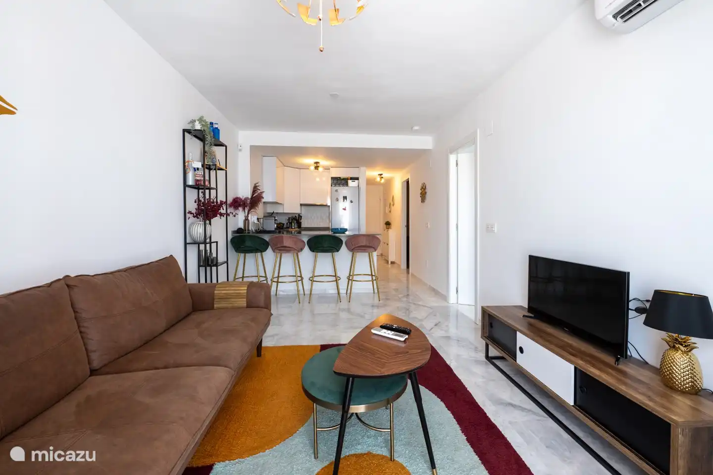 Ein gemütlich eingerichtetes Wohnzimmer mit Schiebetüren zur Terrasse mit Klimaanlage/Heizung.