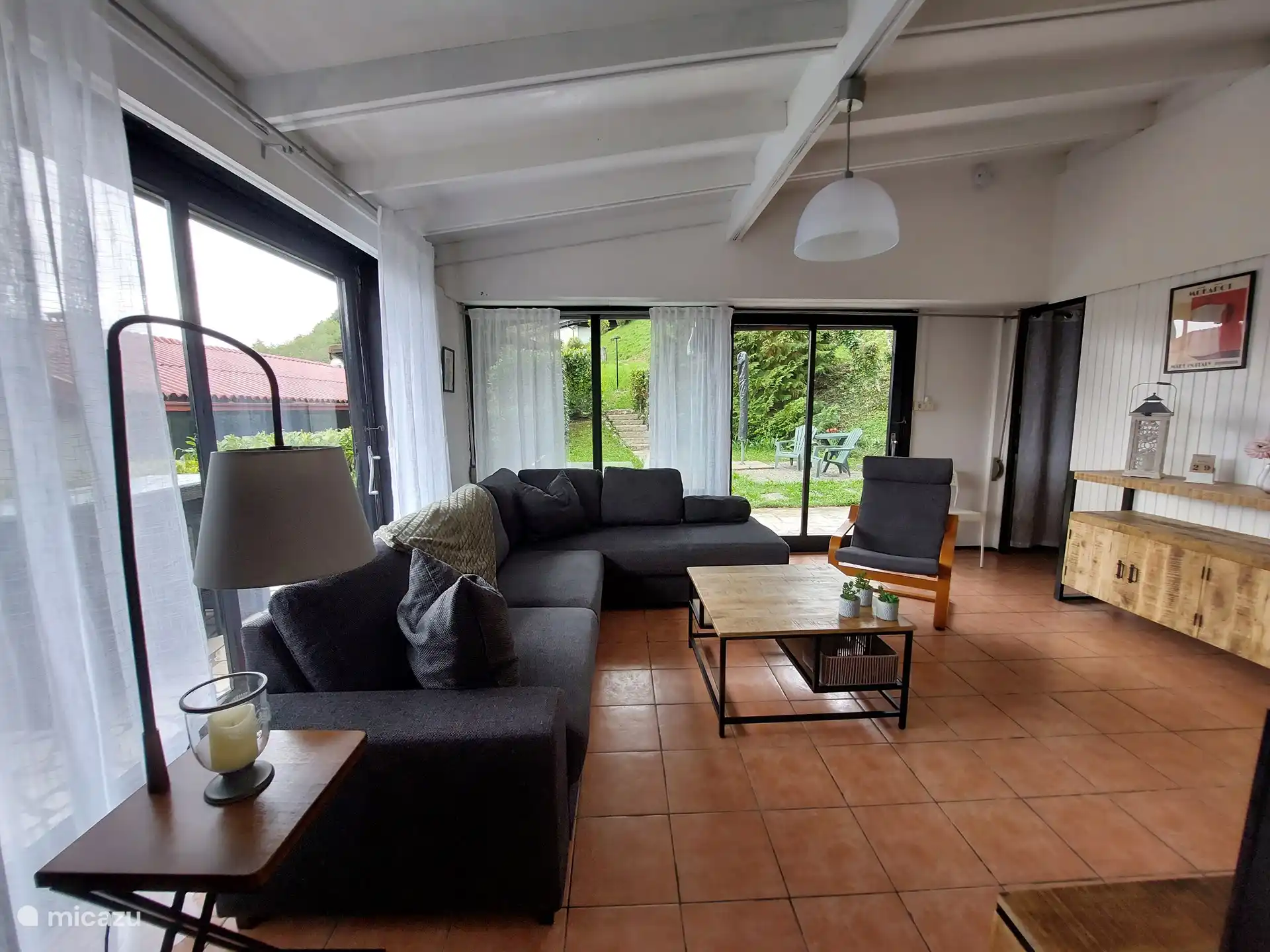 Bonita sala de estar con sofá, silla extra y TV.