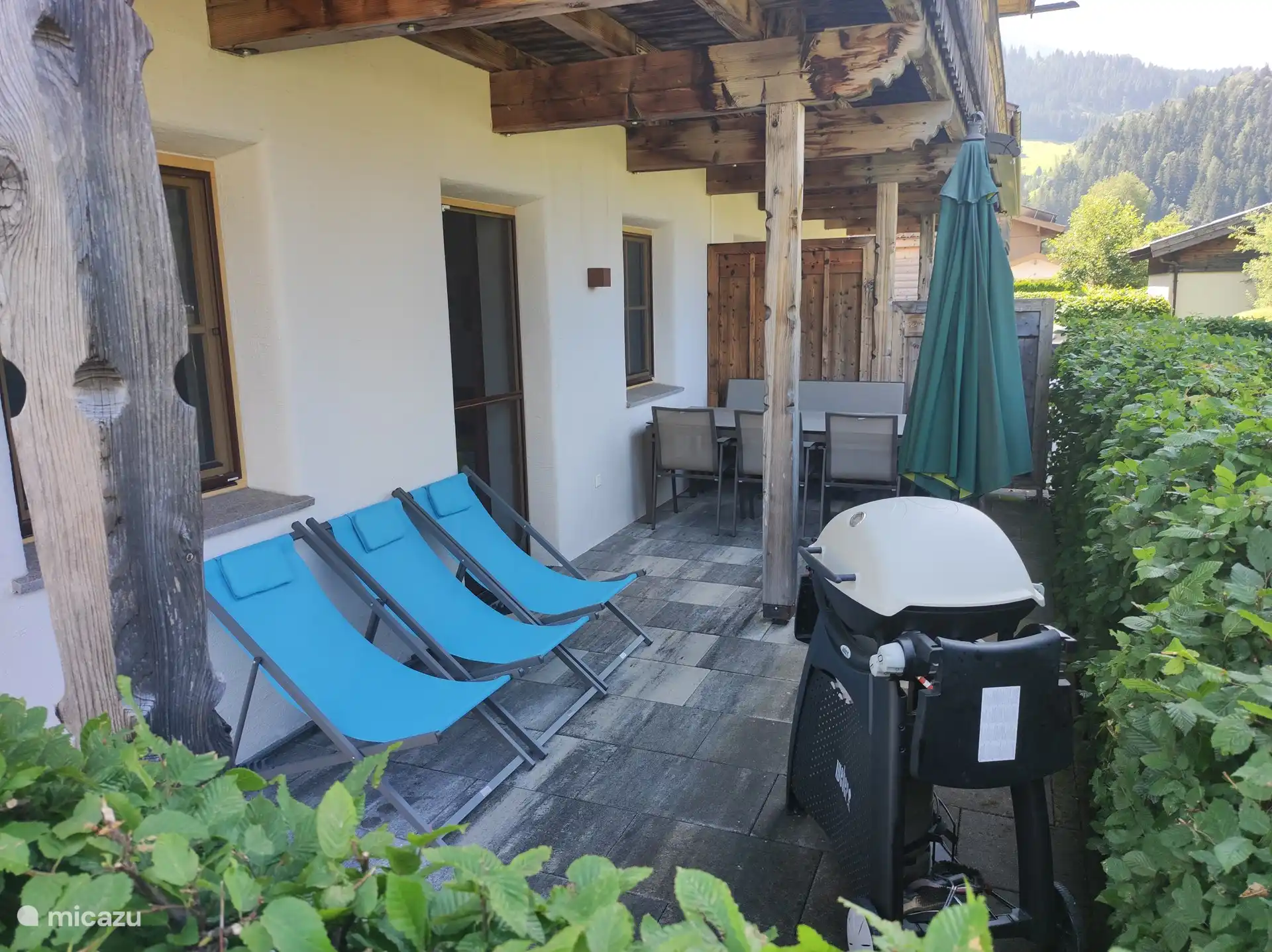 Terras met tuinmeubilair, ligstoelen en Weber gasbarbecue en aangrenzende privé grote tuin