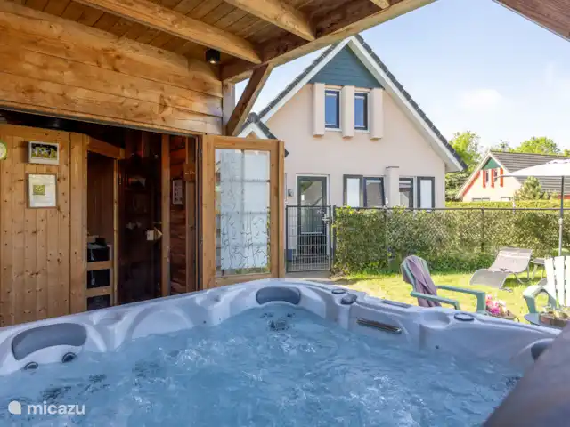 Maison de vacances de luxe avec spa et sauna | Pays-Bas, Frise, Tzummarum - maison de vacances Photo de l’espace bien-être prise de dos.