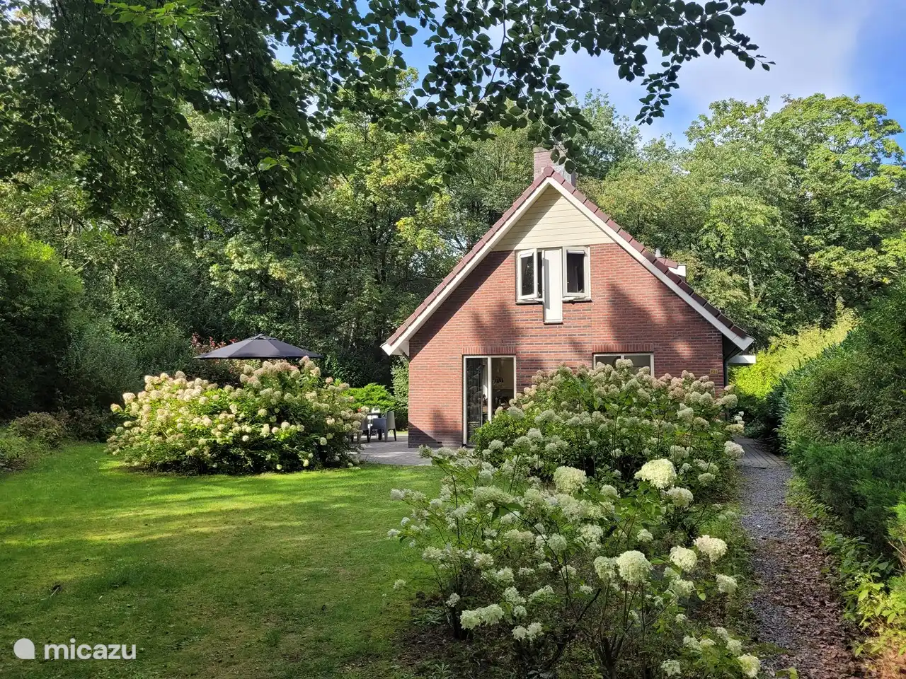 Al lado del bungalow hay una bonita terraza con una amplia mesa de comedor para 8 personas con sombrilla.