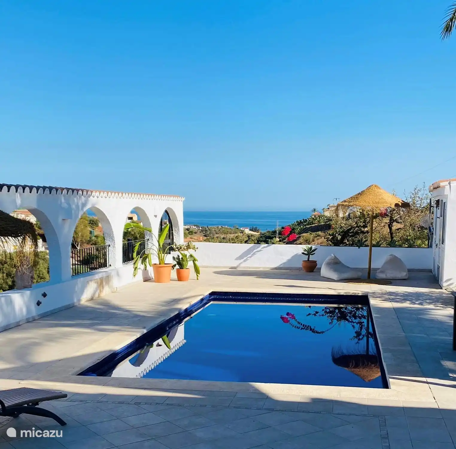 The swimming pool with the azure blue sea in the background