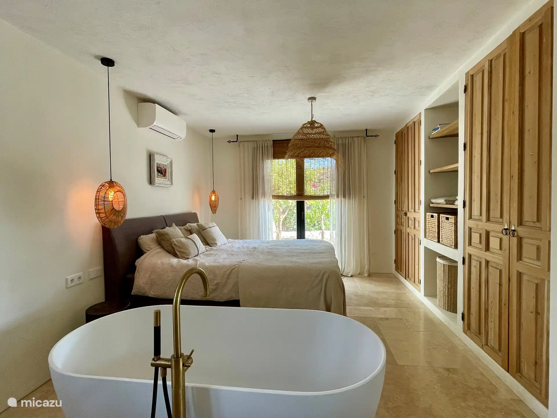 Spacious attractive bedroom with luxurious freestanding bath