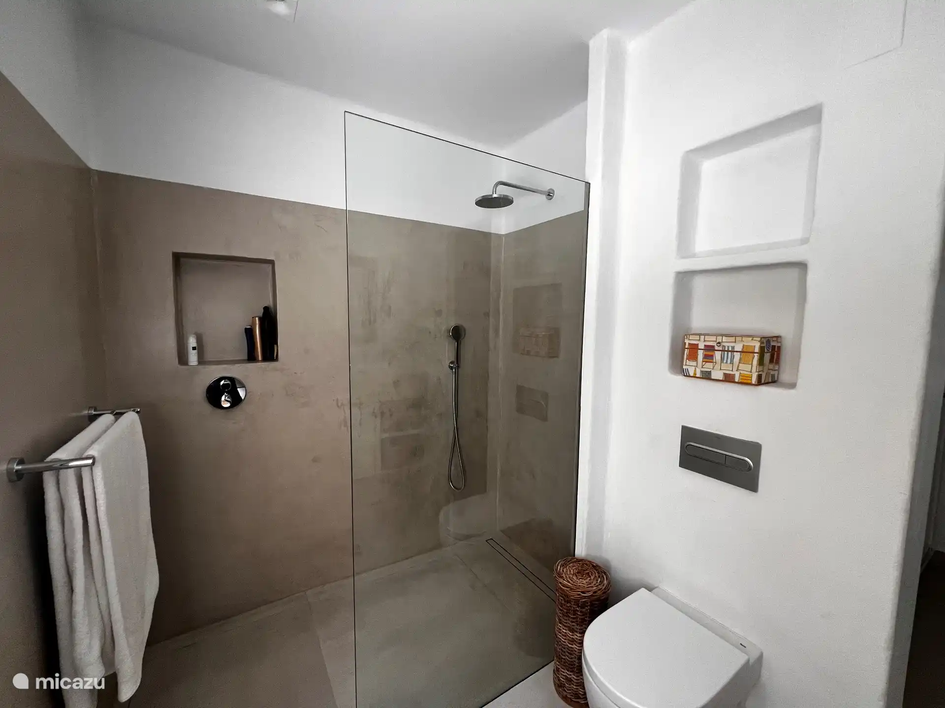 Badezimmer mit ebenerdiger Dusche neben dem Hauptschlafzimmer. 