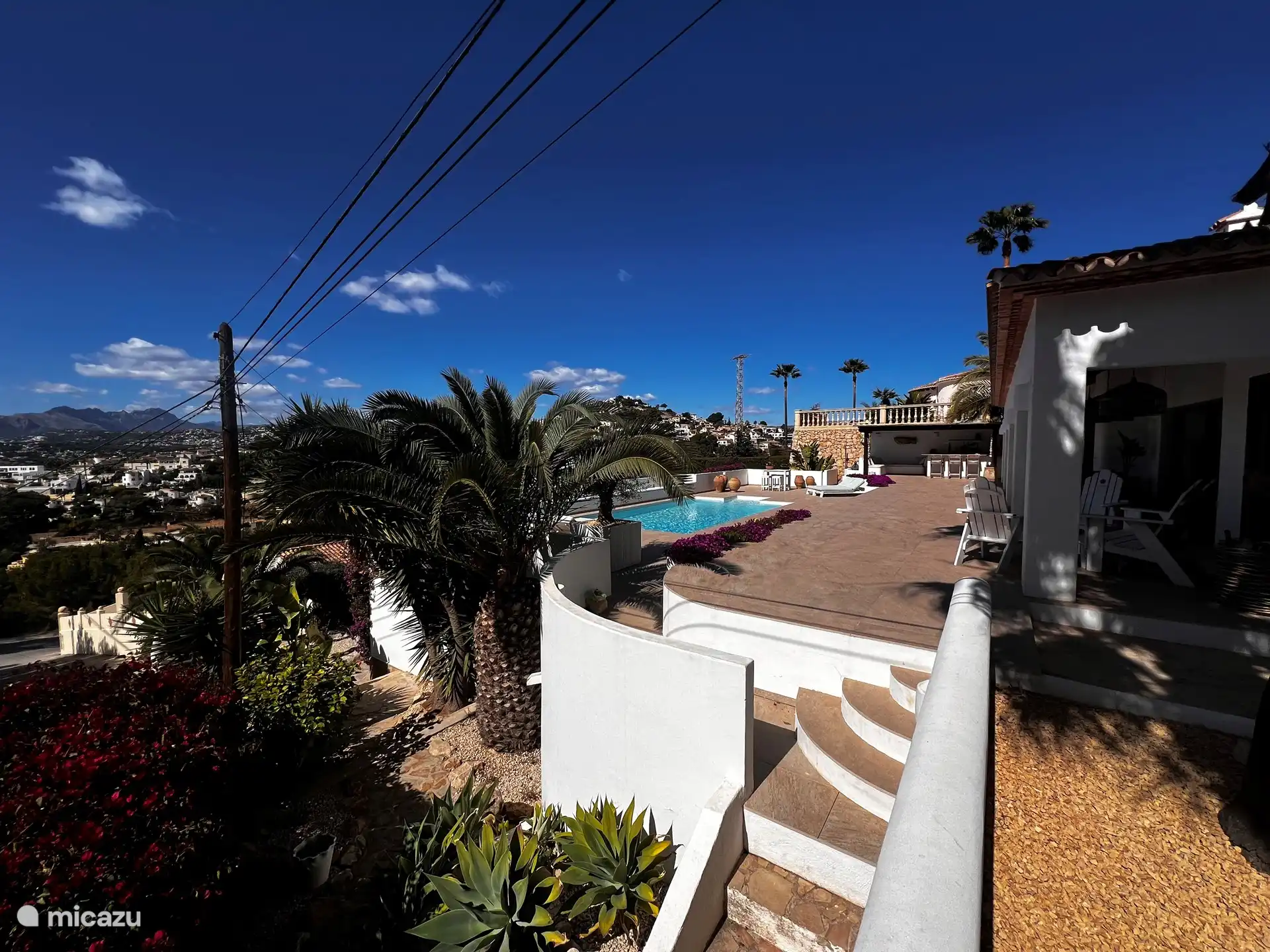 Übersichtsfoto mit Treppe zu den unteren Ebenen mit Obst-/Gemüsegarten und tropischen Pflanzen. 