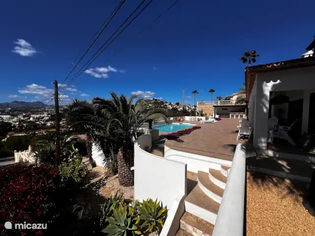 Location de Vacances Espagne, Costa Blanca, Moraira, villa - Villa panoramique de luxe Vista Moraira Photo d'ensemble avec escaliers menant aux niveaux inférieurs avec jardin fruitier/potager et plantes tropicales.