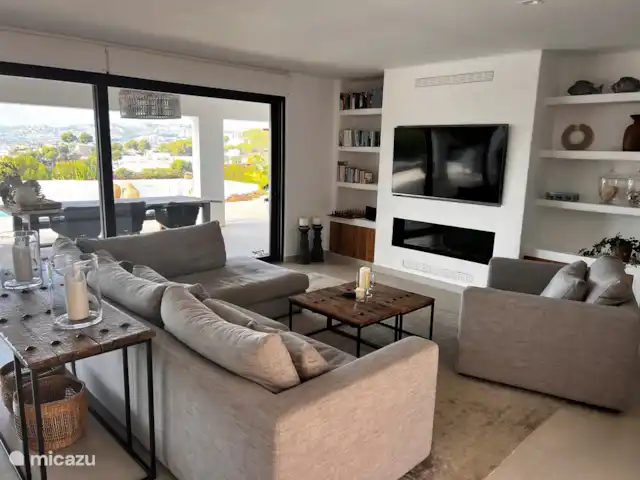 Location de Vacances Espagne, Costa Blanca, Moraira, villa - Villa panoramique de luxe Vista Moraira Le coin salon confortable avec cheminée à gaz, des livres néerlandais et anglais à votre disposition.