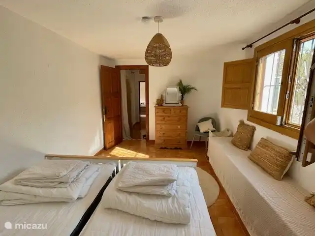 One of the two bedrooms on the ground floor, with two single beds and air conditioning.