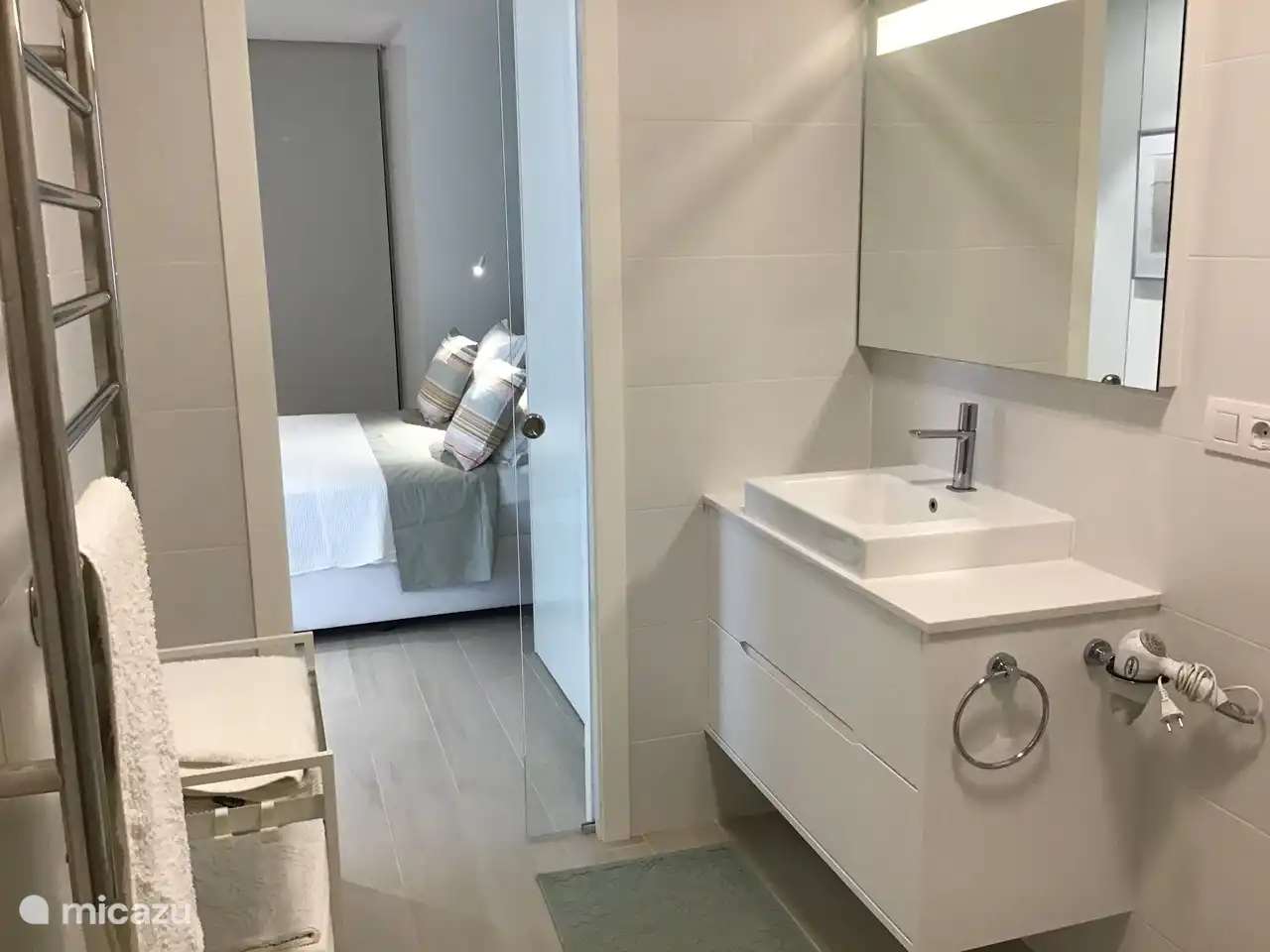 Salle de bain 1 communicante, vue sur chambre 1, lavabo, chauffage électrique d'appoint pour séchage serviettes, maillots de bain....