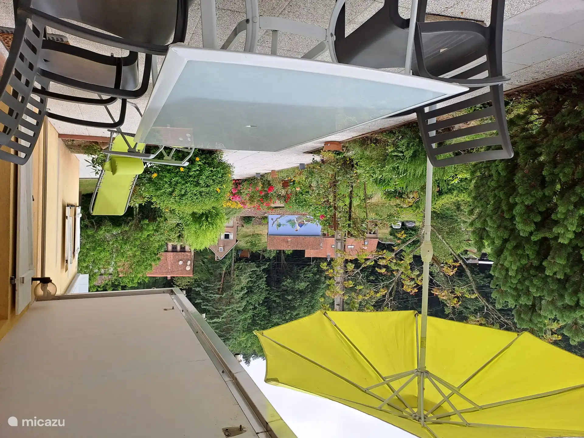 überdachte Terrasse. mit Blick auf den Wald und ein paar Chalets