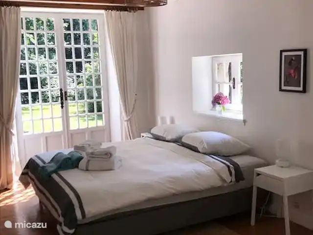 Petit Pezet | France, Charente, Brossac - maison de vacances Salon de jardin - chambre double au rez-de-chaussée, avec douche/WC privés. Portes françaises vers l'avant et vers le jardin.