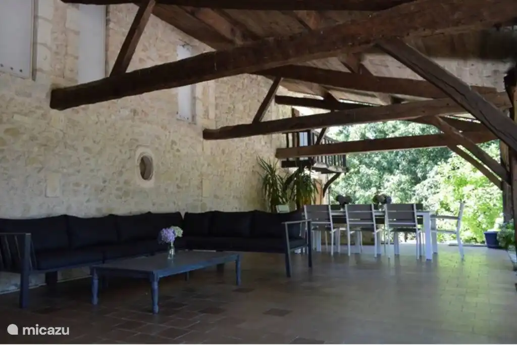 Überdachte Terrasse mit Esstisch und Sitzecke