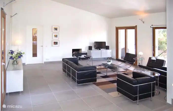 In the spacious living room, adjacent to a veranda, you can watch TV cosily