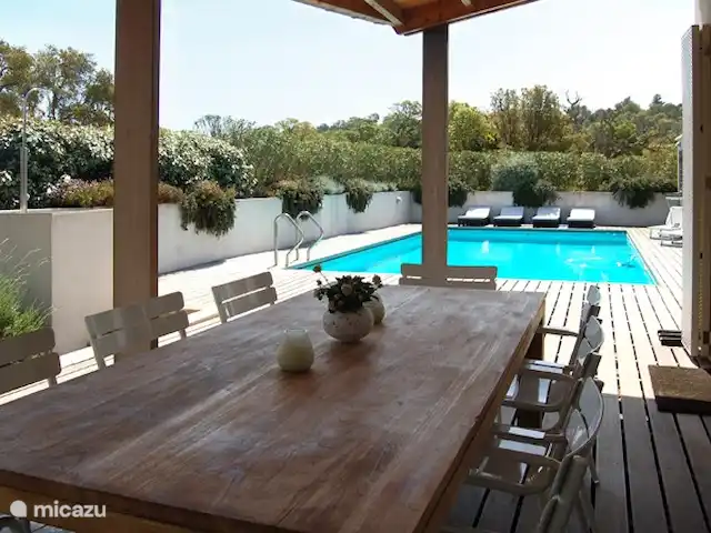 Location de Vacances France, Corse, Sainte-Lucie-de-Porto-Vecchio, villa - Villa Coucou Les Amis Sous la véranda au niveau de la grande table en bois avec 8 chaises vous avez une belle vue sur les terrasses, le jardin et la piscine