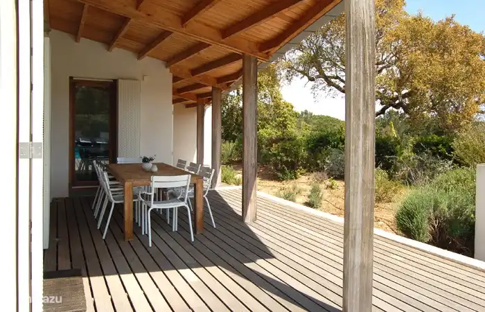 You can find shade under the porch at the large wooden table with eight chairs