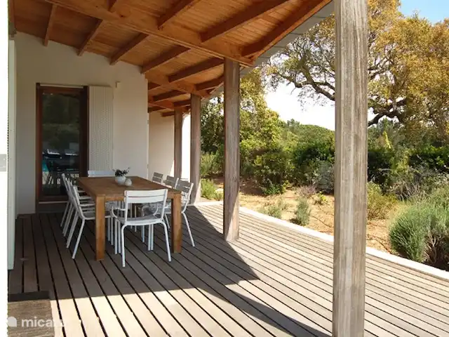 Location de Vacances France, Corse, Sainte-Lucie-de-Porto-Vecchio, villa - Villa Coucou Les Amis Vous pouvez trouver de l'ombre sous la véranda près de la grande table en bois avec huit chaises.