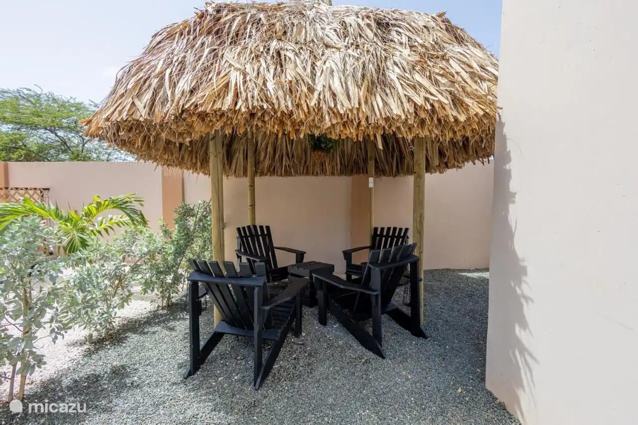 Palapa met tafel en vier stoelen om rustig te kunnen genieten onder een overkapping