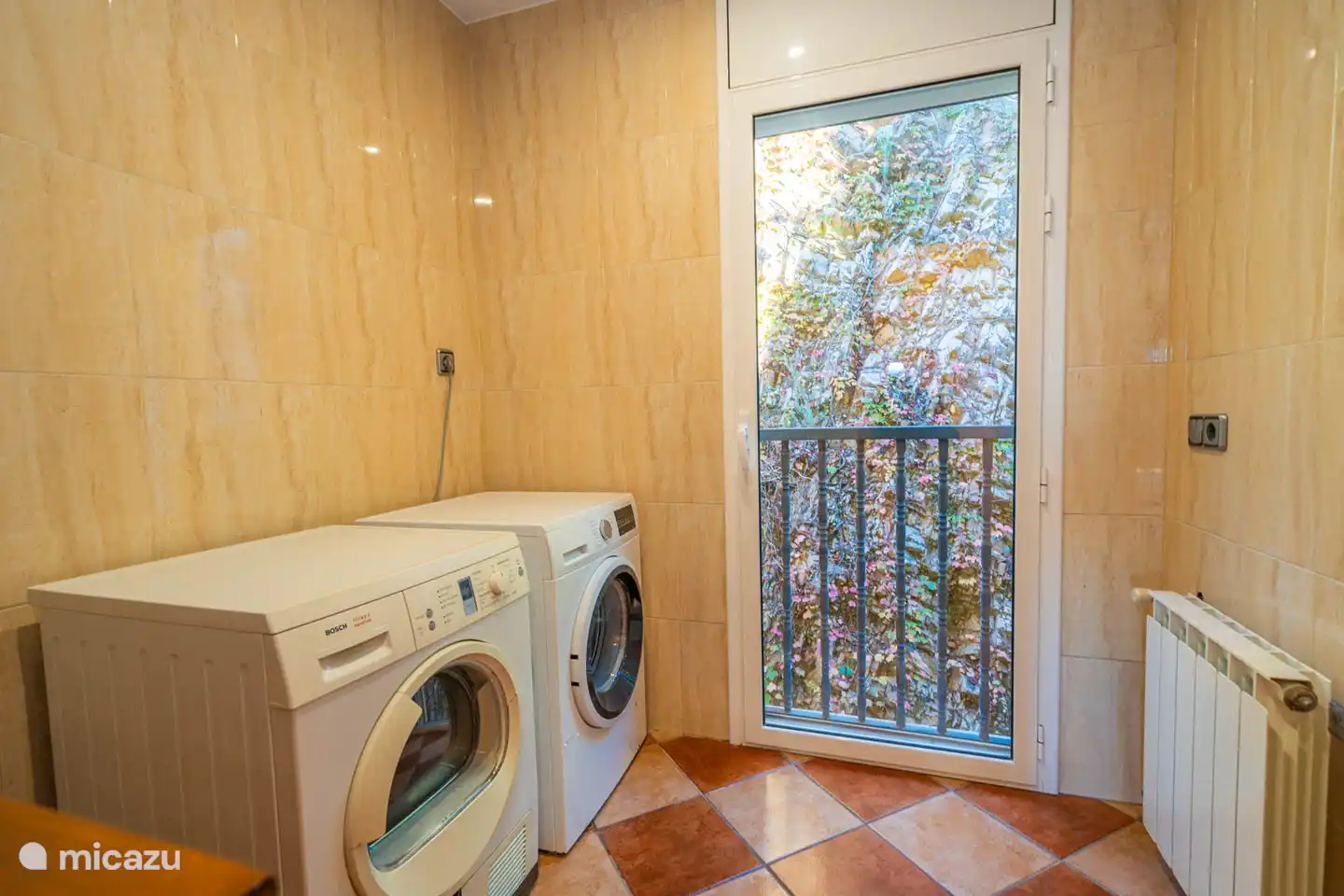 Wasruimte met wasmachine, droger, droogrek, strijktafel en strijkbout