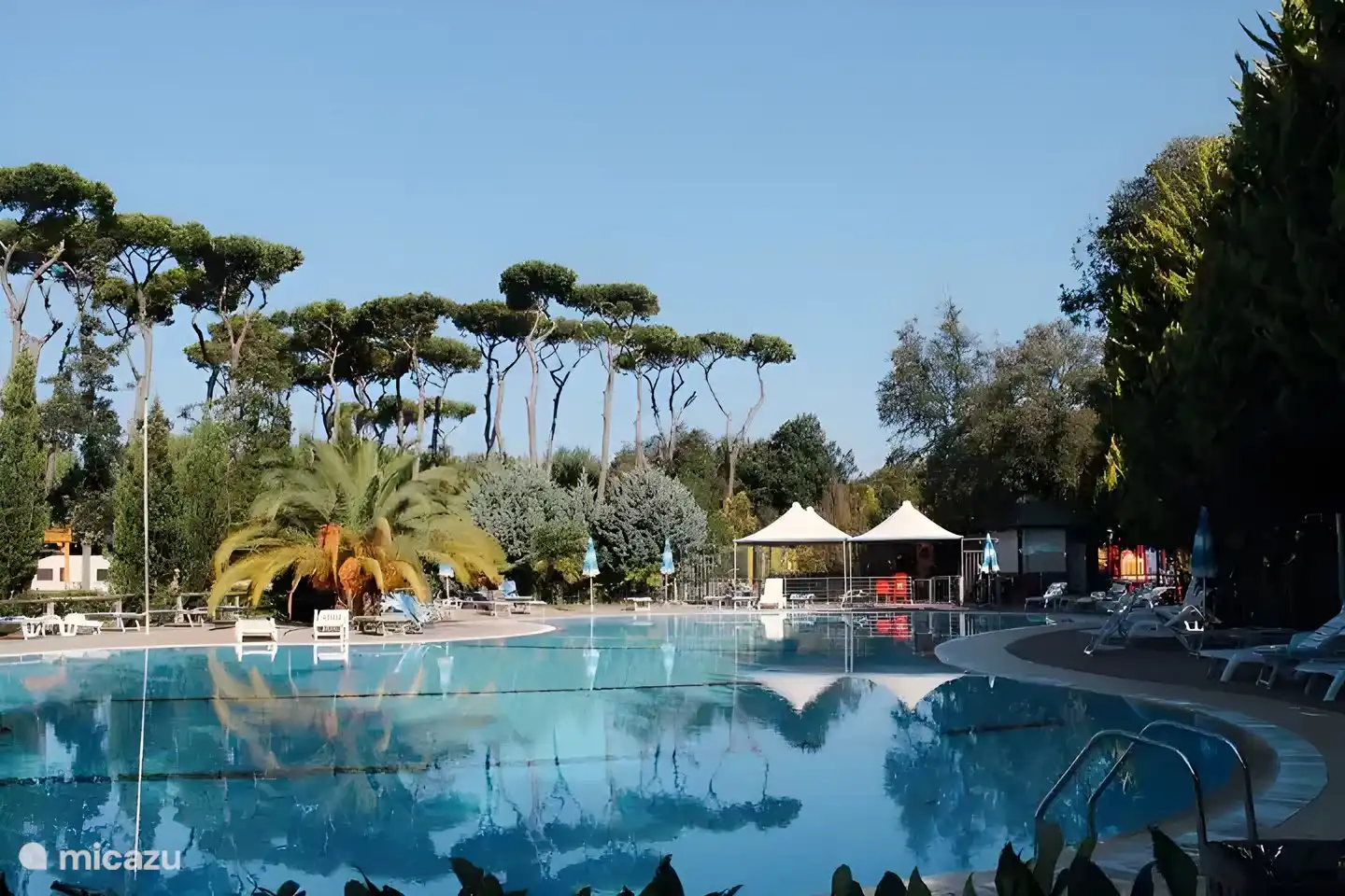 Une belle piscine avec transats et parasols
