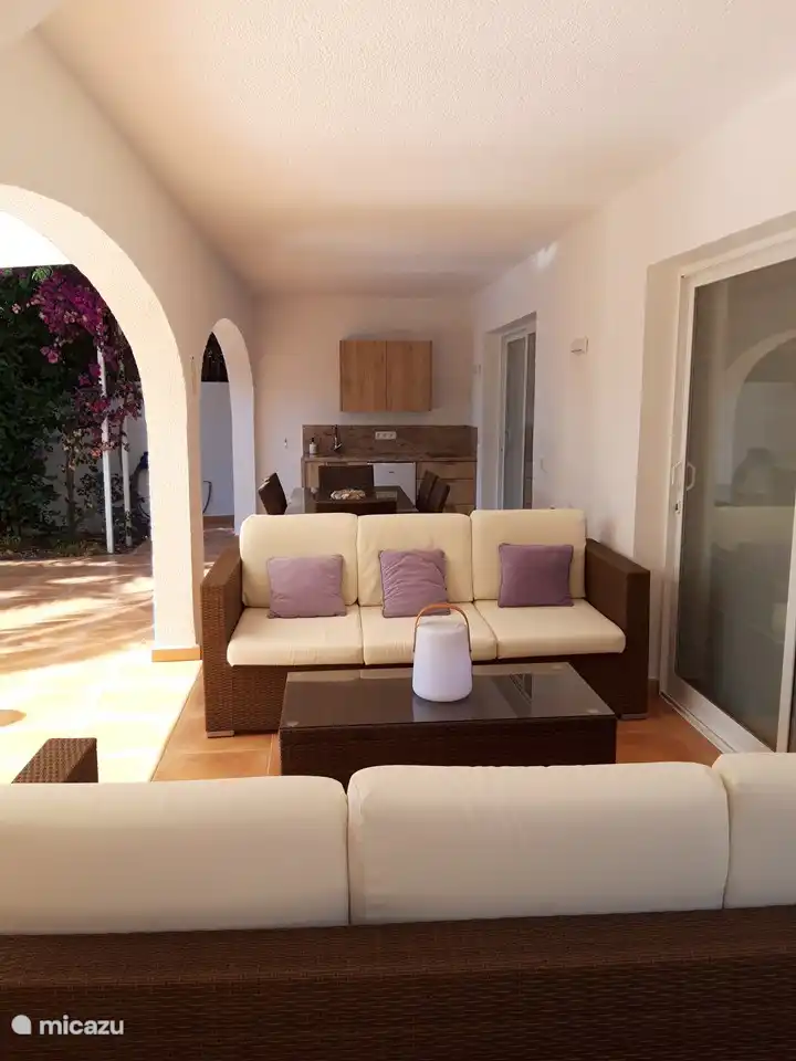 covered terrace with outdoor kitchen, dining table and lounge