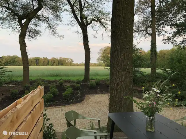 De Boschkerhook huren in Nederland, Gelderland, Vragender - vakantiehuis Het terras met uitzicht over het veld. Tuinstoelkussens en een parasol zijn aanwezig.