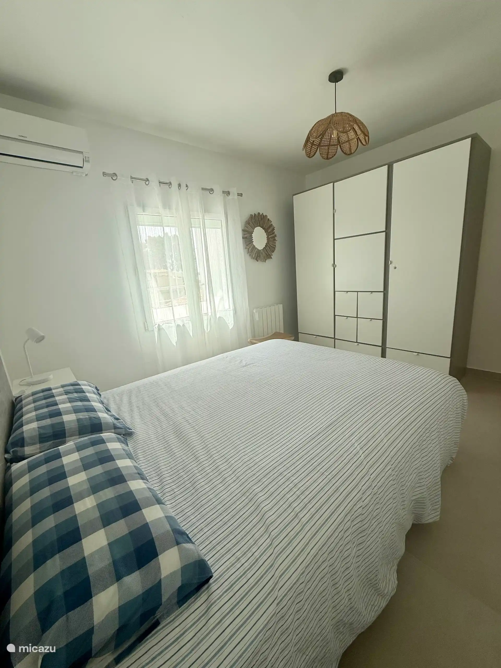 Dormitorio con armario, aire acondicionado y persiana eléctrica