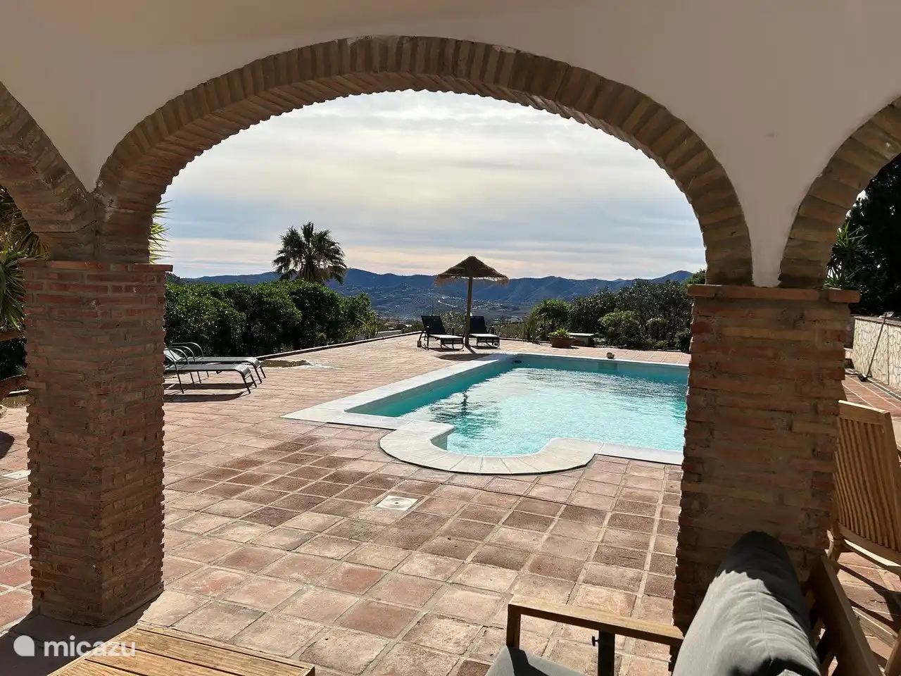 Der Swimmingpool von der überdachten Terrasse aus