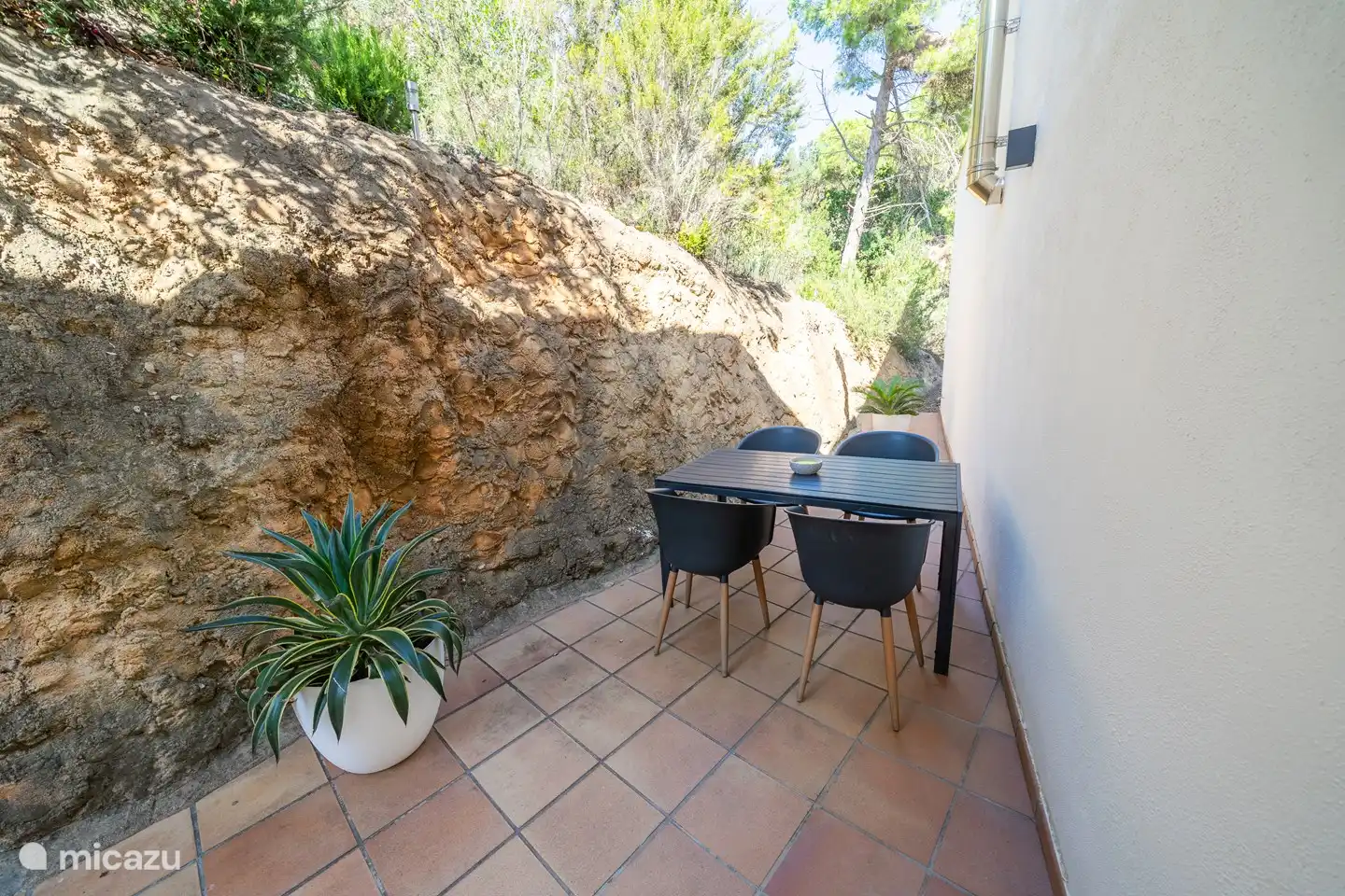 Am Eingang haben Sie auch eine Tür zu einer kleinen Terrasse hinter dem Haus, wo Sie im Schatten entspannen können