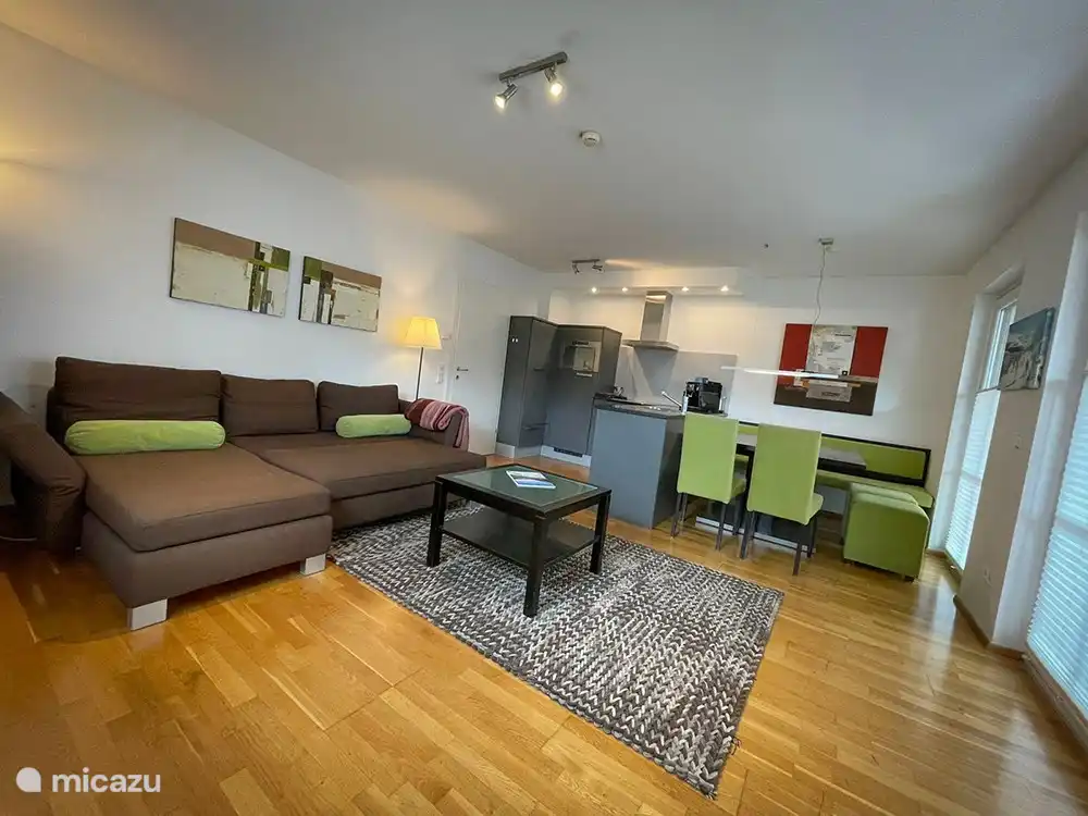 Das Wohnzimmer, komplett ausgestattet, mit Küche, Esstisch und Sitzecke.