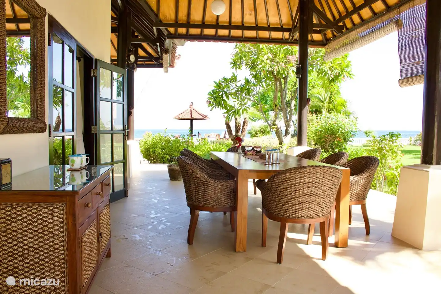 Una hermosa y espaciosa terraza al costado de la casa, que es un lugar maravilloso para sentarse en una mesa grande para 10 personas.
