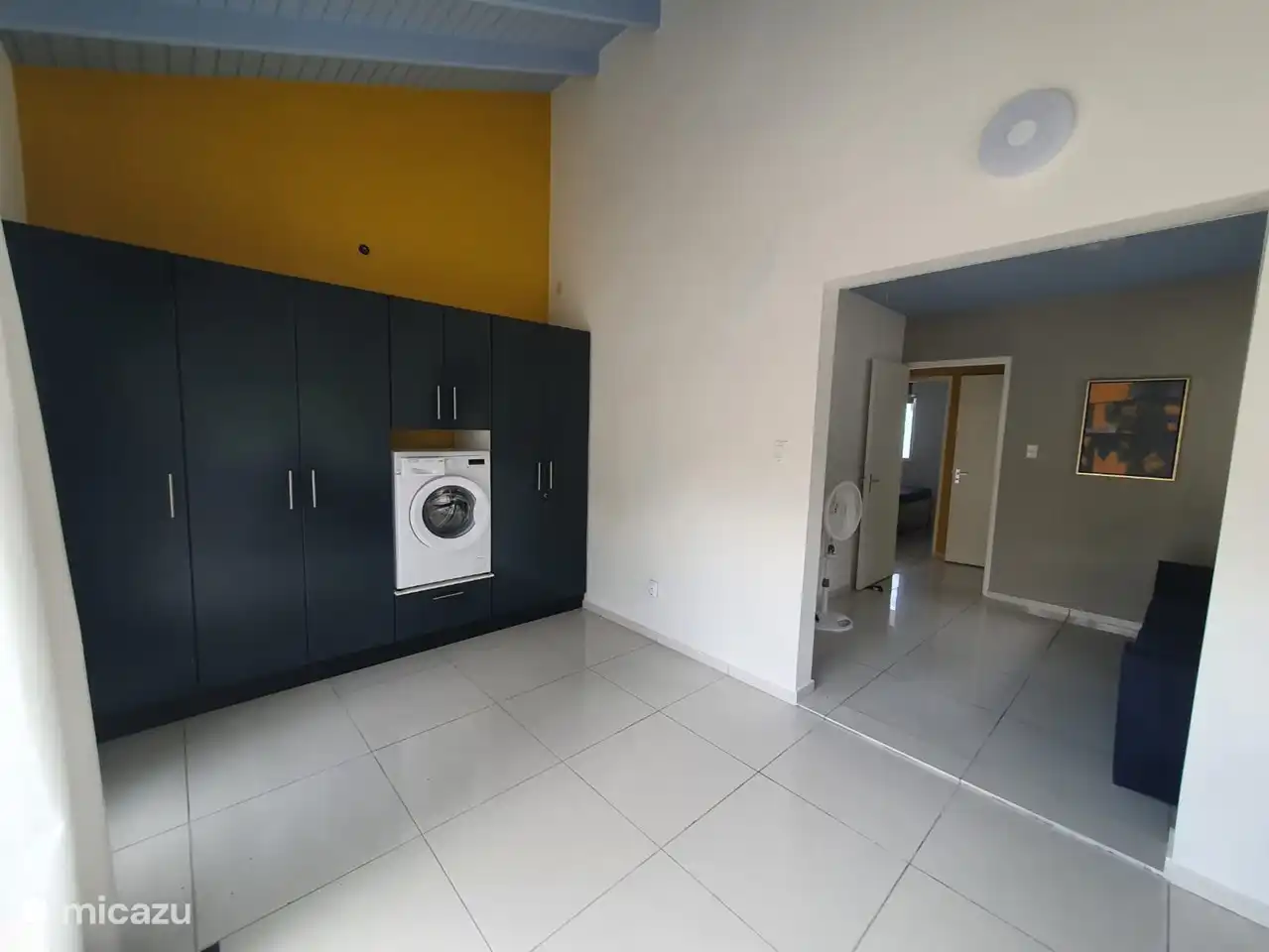 In the room next to bedroom 3 there is a large cupboard wall with work cupboards and washing machine.