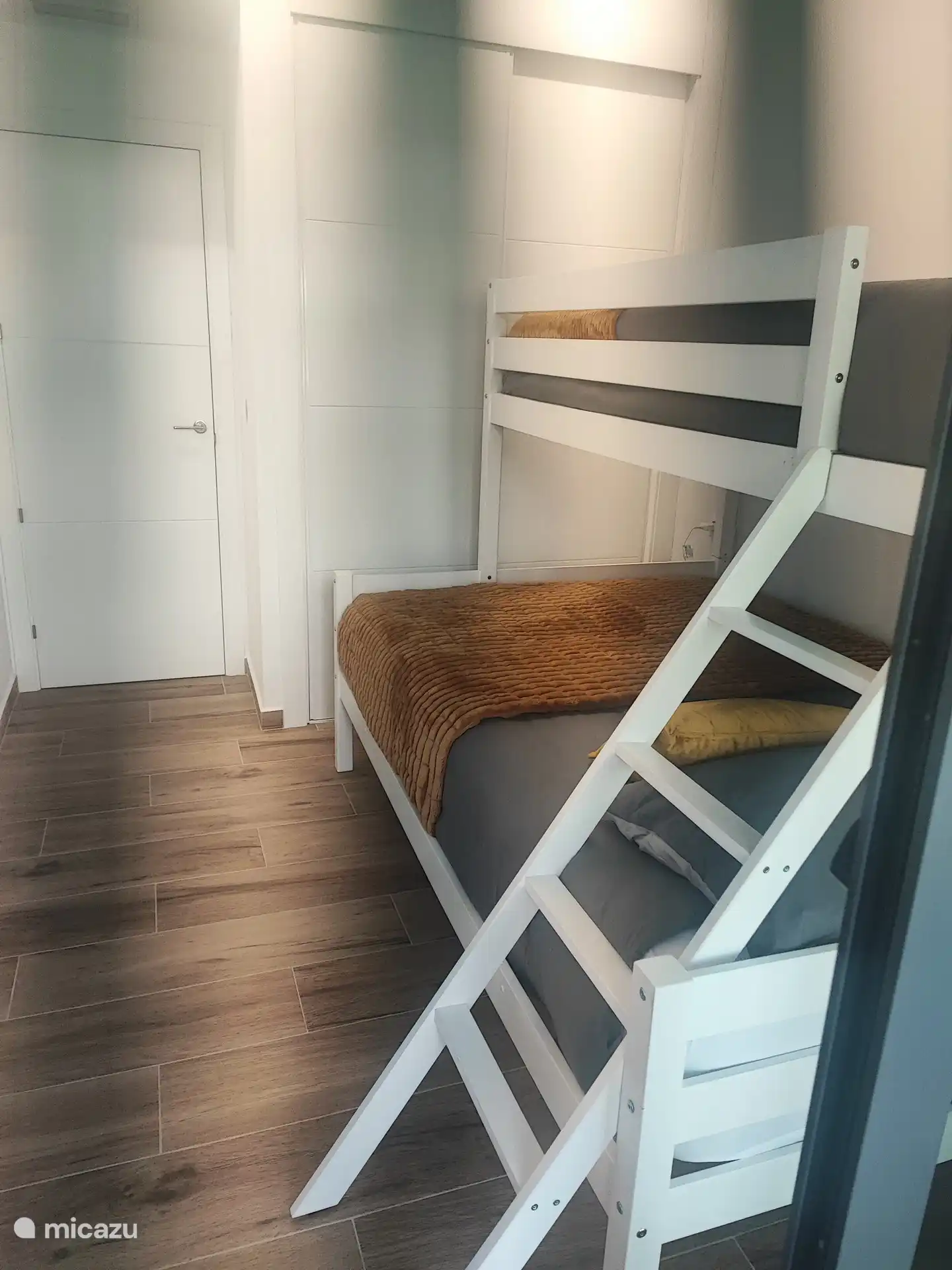 Deuxième chambre avec un lit superposé pour trois personnes et une armoire intégrée 