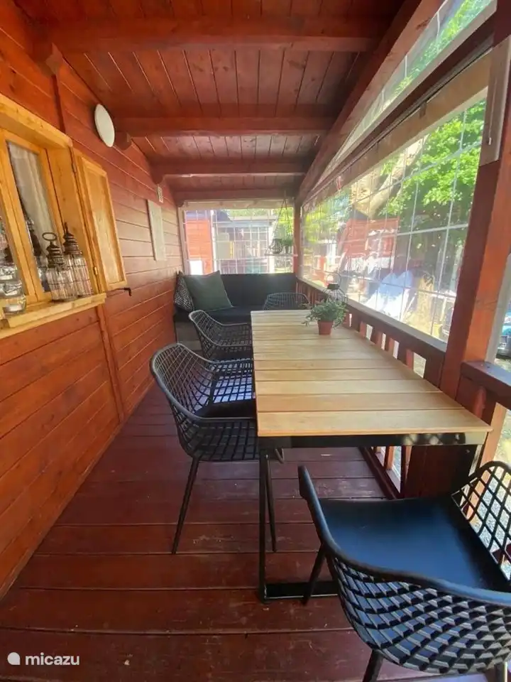 De veranda, met zitbank en tafel met 4 stoelen