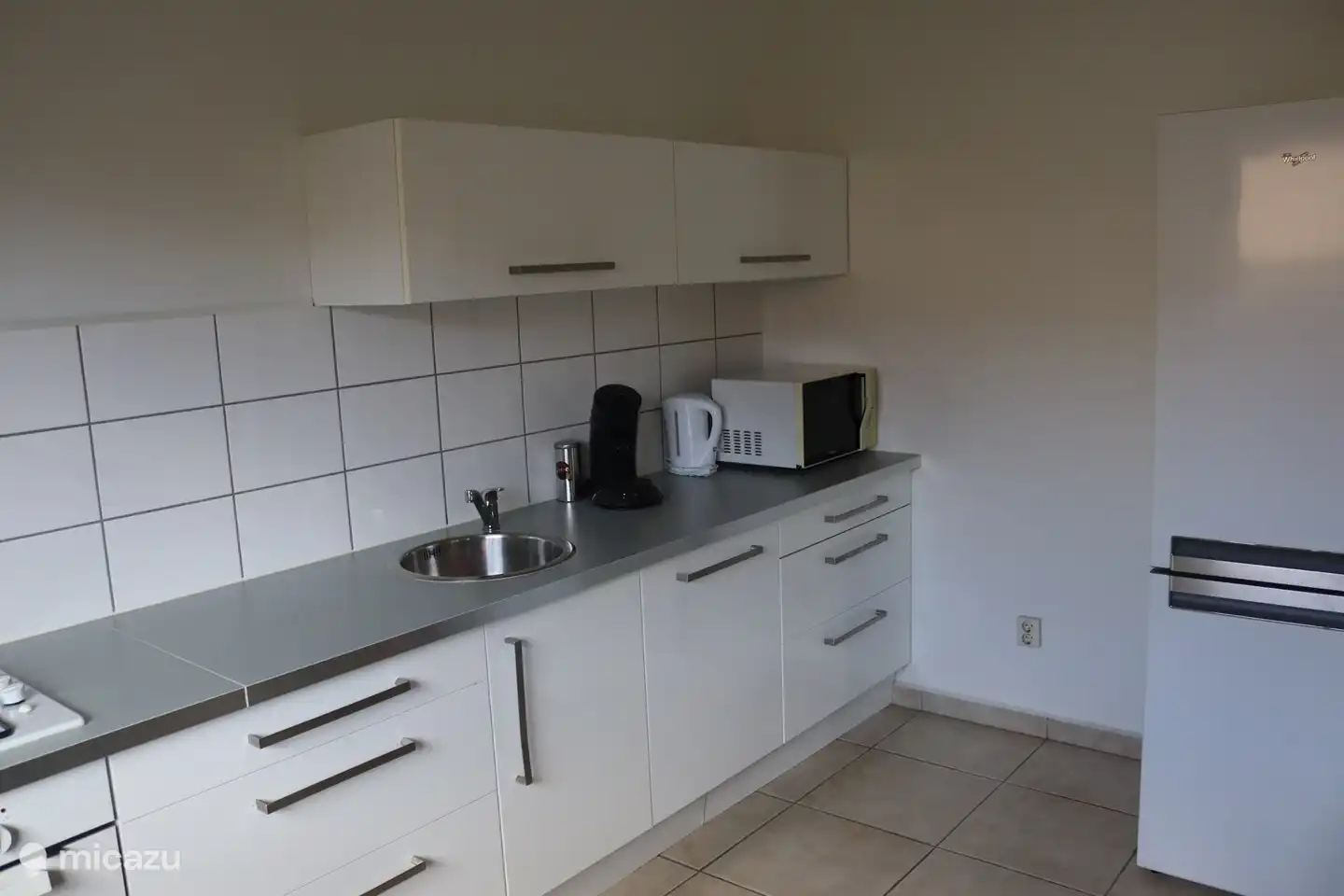Kitchen including dishwasher, washing machine, oven, refrigerator and microwave.