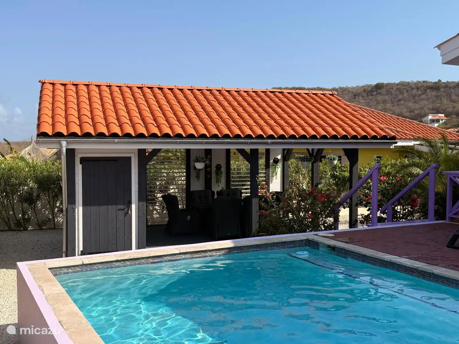Depuis la piscine, on regarde directement dans la couverture du jardin.
On y entre par l’escalier violet sur le côté.