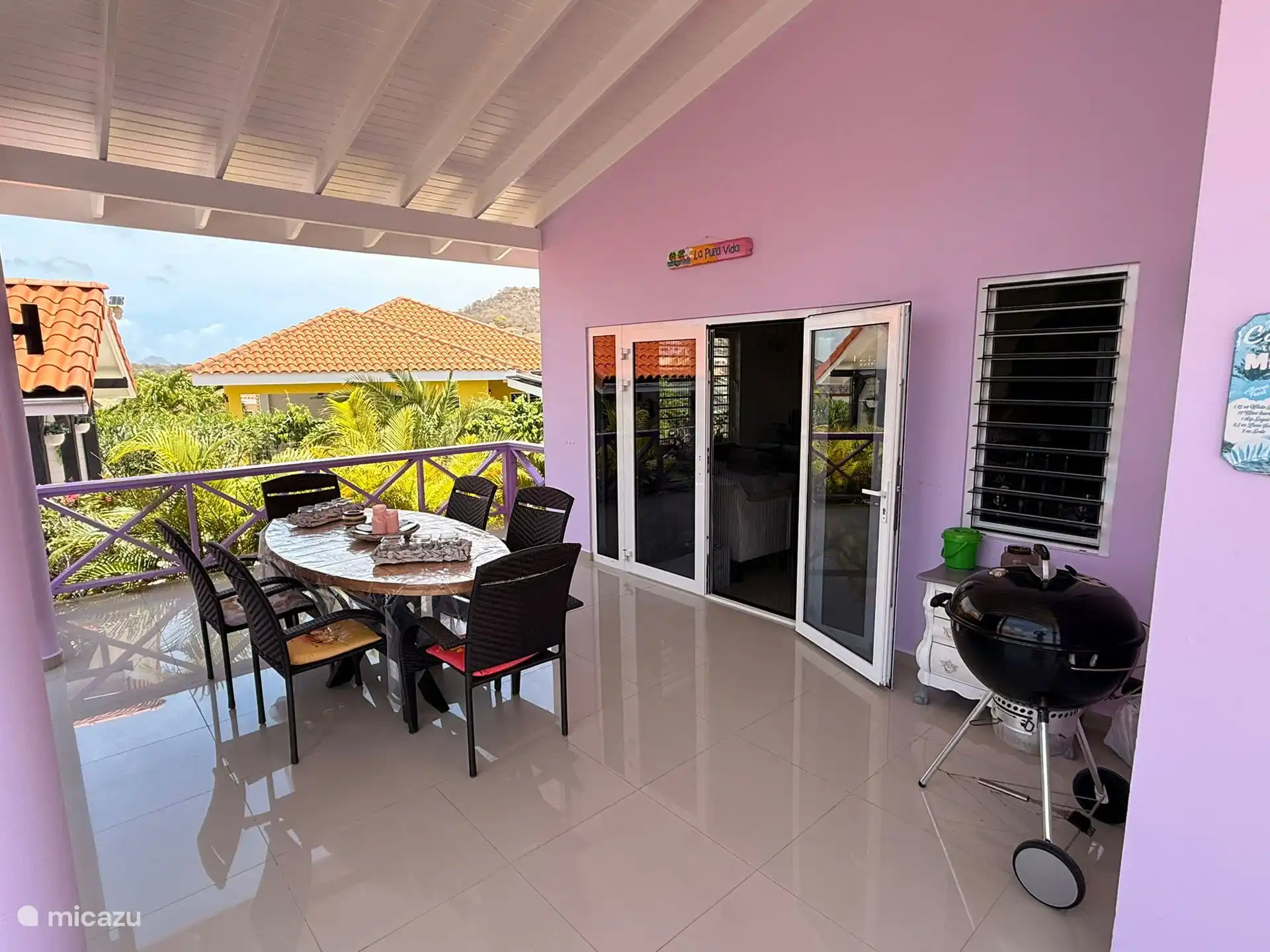 Sur la véranda se trouve la table à manger pour la toile d’ombrage et le barbecue.