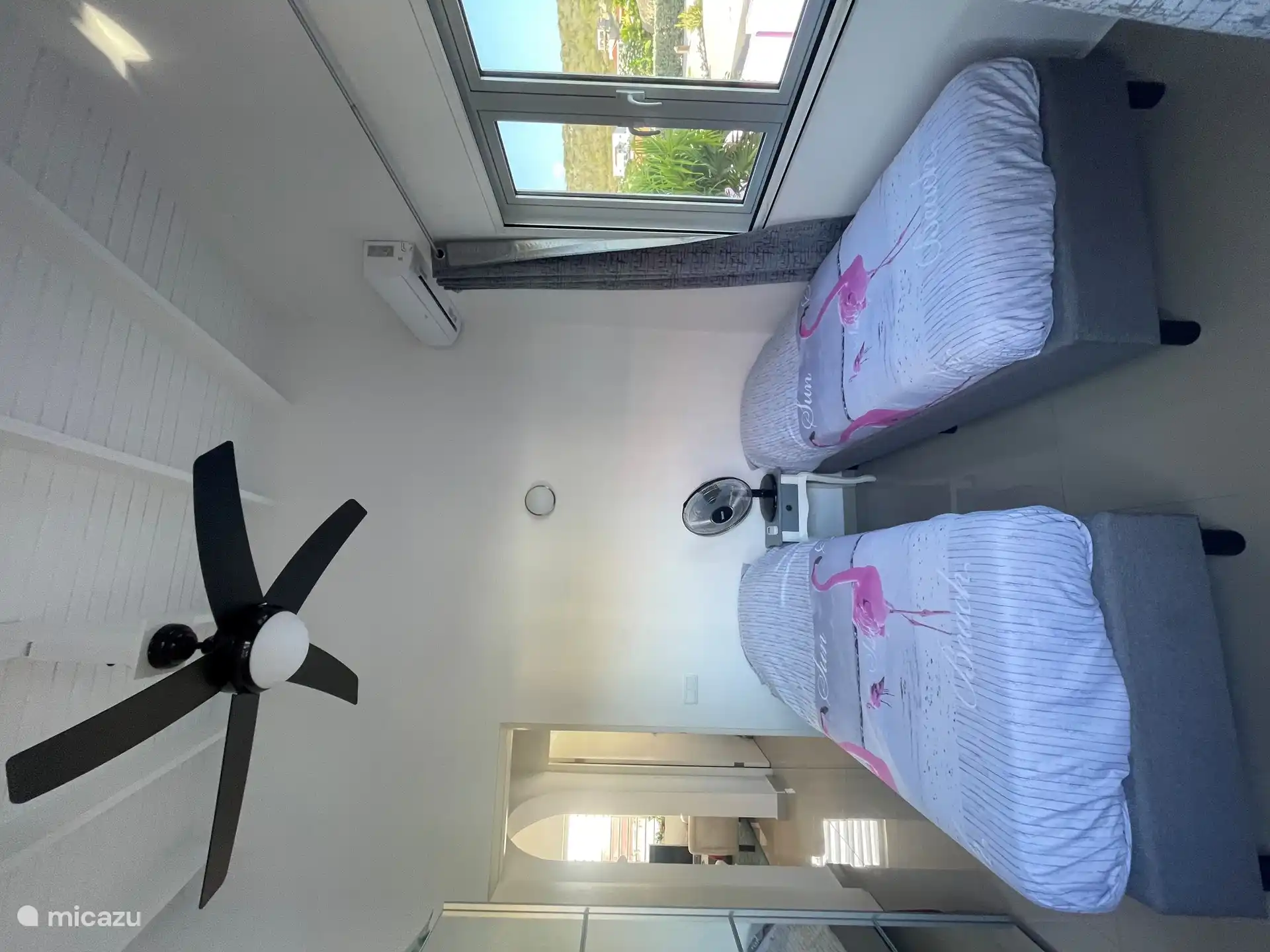Schlafzimmer rechts mit 2 Einzelbetten, Deckenventilator und Klimaanlage.