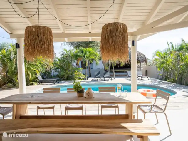 Location de Vacances Curaçao, Banda Ariba (est), Jan Thiel, maison de vacances - Casa Cosi Curaçao - Plage Jan Thiel Longue table en tronc d'arbre sous la véranda